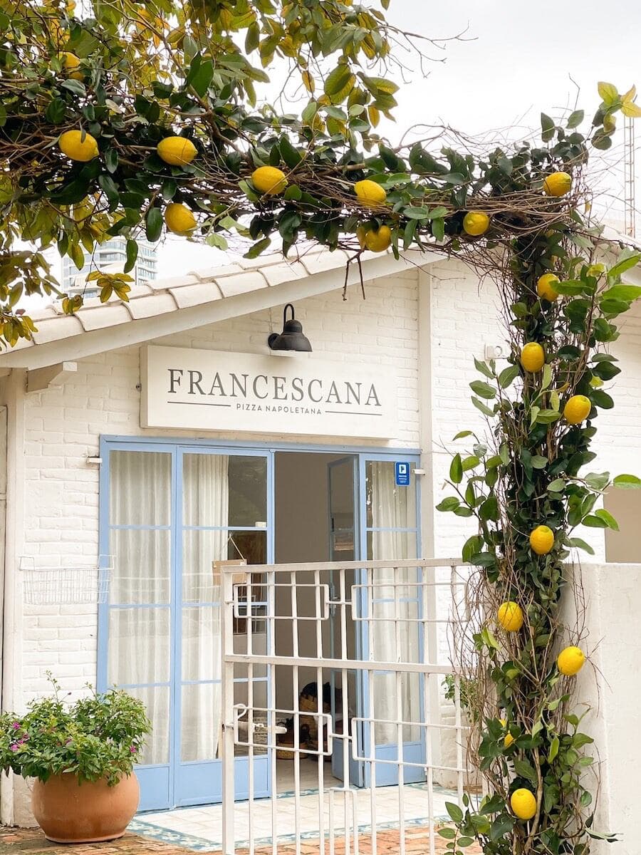 Fachada de La Francescana, pizza napoletana, con limoneros en la entrada.